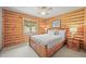 Comfortable bedroom with natural light, carpeted floors and log paneled walls at 9868 Overlook Rd, Sedalia, CO 80135