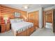 Comfortable bedroom with log walls, a ceiling fan, and a view into the hallway at 9868 Overlook Rd, Sedalia, CO 80135