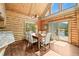 Cozy dining room with a wooden table set, log walls, and natural light from the windows at 9868 Overlook Rd, Sedalia, CO 80135