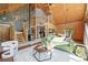 Living room with log walls, soaring ceilings, stone fireplace, wood staircase and an open floor plan at 9868 Overlook Rd, Sedalia, CO 80135