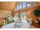 Living room featuring log walls, high ceilings with large windows, and an open-concept living space at 9868 Overlook Rd, Sedalia, CO 80135
