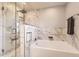 Luxurious bathroom with a glass-enclosed shower and soaking tub, adorned with marble tiling for a sleek aesthetic at 20910 Omaha Ave, Parker, CO 80138