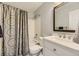 Neat bathroom with a shower-tub combo, a white vanity, and a decorative mirror at 20910 Omaha Ave, Parker, CO 80138