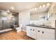 Modern bathroom featuring dual sink vanity with black countertops and a walk-in shower at 3225 Olive St, Denver, CO 80207