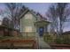 Charming two-story home featuring a cozy front porch and landscaped garden at twilight at 3225 Olive St, Denver, CO 80207