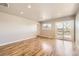 Spacious living room with hardwood floors, recessed lighting, and access to outdoor balcony at 3225 Olive St, Denver, CO 80207