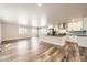 Open-concept floor plan connecting the modern kitchen and living area with hardwood floors at 3225 Olive St, Denver, CO 80207
