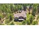 Aerial view of a home featuring an expansive deck surrounded by green trees and a large backyard at 1653 Gore Dr, Larkspur, CO 80118