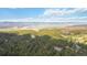 Stunning aerial view of lush greenery, rolling hills, and distant mountains creating a tranquil setting at 1653 Gore Dr, Larkspur, CO 80118