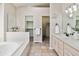 Large primary bathroom featuring double sinks, soaking tub, and walk in closet at 1653 Gore Dr, Larkspur, CO 80118