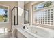 Bright bathroom with a soaking tub, glass brick window, and tiled shower at 1653 Gore Dr, Larkspur, CO 80118