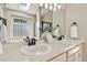 Bathroom featuring double sinks, a soaking tub, glass block and neutral tile at 1653 Gore Dr, Larkspur, CO 80118