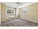 Bedroom with carpeted floor, ceiling fan, and two windows that provide natural light with views of trees at 1653 Gore Dr, Larkspur, CO 80118