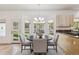 Cozy breakfast nook with round table, natural light, and view of the lush green backyard at 1653 Gore Dr, Larkspur, CO 80118
