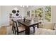 Bright dining room featuring wood table, decorative wall art, and large window with forest view at 1653 Gore Dr, Larkspur, CO 80118