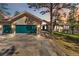 Stunning home featuring a green garage door, stone driveway, and mature trees at 1653 Gore Dr, Larkspur, CO 80118