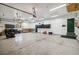 Spacious garage featuring a sealed concrete floor, storage cabinets, and a secondary exterior door at 1653 Gore Dr, Larkspur, CO 80118