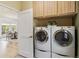 Convenient laundry room features front-load washer and dryer with storage, adjacent to the dining area at 1653 Gore Dr, Larkspur, CO 80118