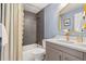 Bathroom includes tiled shower and tub, unique light fixture and modern vanity at 7092 E Mexico Ave, Denver, CO 80224