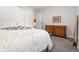 Spacious bedroom with closet, wood dresser, and neutral carpet floors at 7092 E Mexico Ave, Denver, CO 80224
