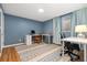 Study room with blue walls, a patterned rug and an L-shaped white desk at 7092 E Mexico Ave, Denver, CO 80224