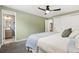 Green bedroom offers a ceiling fan, carpet floors and ensuite bathroom at 7092 E Mexico Ave, Denver, CO 80224