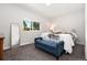 Well-lit bedroom with large window and a comfortable blue bench at 7092 E Mexico Ave, Denver, CO 80224