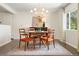 Elegant dining room with hardwood floors, designer lighting, and a serene view from the window at 7092 E Mexico Ave, Denver, CO 80224