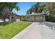 Charming single-story home features a well-manicured lawn, attached garage, and bright orange front door at 7092 E Mexico Ave, Denver, CO 80224