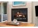 Close up of a cozy fireplace with a stone surround and a wood burning insert at 7092 E Mexico Ave, Denver, CO 80224