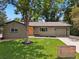 Charming home with well-manicured front yard, mature trees, and an inviting orange front door at 7092 E Mexico Ave, Denver, CO 80224