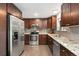 Beautiful kitchen with stainless steel appliances, granite countertops, and ample dark wood cabinet space at 7092 E Mexico Ave, Denver, CO 80224