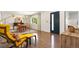 Modern living area boasts hardwood floors, a stylish yellow lounge chair, and a sun-filled dining space at 7092 E Mexico Ave, Denver, CO 80224
