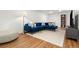 Modern living room featuring stylish blue velvet sectional sofa, ottoman, and hardwood floors at 7092 E Mexico Ave, Denver, CO 80224