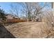 Large backyard featuring wooden fence, mature trees, and a level, grassy area at 6823 Coors St, Arvada, CO 80004