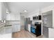 Modern kitchen with new appliances, light countertops, and abundant natural light is open to the living area at 6823 Coors St, Arvada, CO 80004