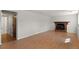 Spacious living room features a brick fireplace, wood laminate flooring, and a neutral color palette at 6823 Coors St, Arvada, CO 80004