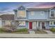 Charming townhome with a red front door, light blue siding, and manicured landscaping at 19046 E 57Th Pl # B, Denver, CO 80249