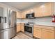 Spacious kitchen with stainless steel appliances, wood cabinetry, and ample counter space at 19046 E 57Th Pl # B, Denver, CO 80249