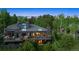 Aerial view of home, backing to lush woods, showing multi-level outdoor living spaces at 24036 Currant Dr, Golden, CO 80401