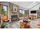 Inviting living room boasts a stone fireplace, vaulted ceilings, and an open layout leading to an outdoor deck at 24036 Currant Dr, Golden, CO 80401