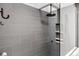 Contemporary shower featuring stylish gray tiling, a rainfall shower head, and a built-in niche at 24036 Currant Dr, Golden, CO 80401