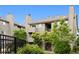 Apartment building with a private balcony surrounded by green trees at 3100 S Federal Blvd # 331, Denver, CO 80236