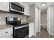 Modern kitchen featuring stainless steel appliances and white cabinetry with a glimpse into the bathroom at 3100 S Federal Blvd # 331, Denver, CO 80236