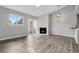 Open-concept living room with fireplace, wood floors, and natural light from windows and sliding doors at 3100 S Federal Blvd # 331, Denver, CO 80236