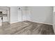 Bright living area featuring modern gray wood floors, fresh white walls, and an abundance of natural light at 3100 S Federal Blvd # 331, Denver, CO 80236