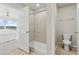 Bathroom featuring a glass shower door, toilet, and sink near a bedroom with exterior views at 762 N Rome St, Aurora, CO 80018