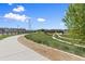 Scenic community path with lush greenery, pedestrian bridge, and clear blue skies at 762 N Rome St, Aurora, CO 80018