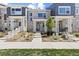 Stylish townhome featuring a modern stone facade, covered entry, and manicured landscaping at 762 N Rome St, Aurora, CO 80018