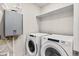 Modern laundry room featuring front-load washer and dryer, plus a tankless water heater at 762 N Rome St, Aurora, CO 80018